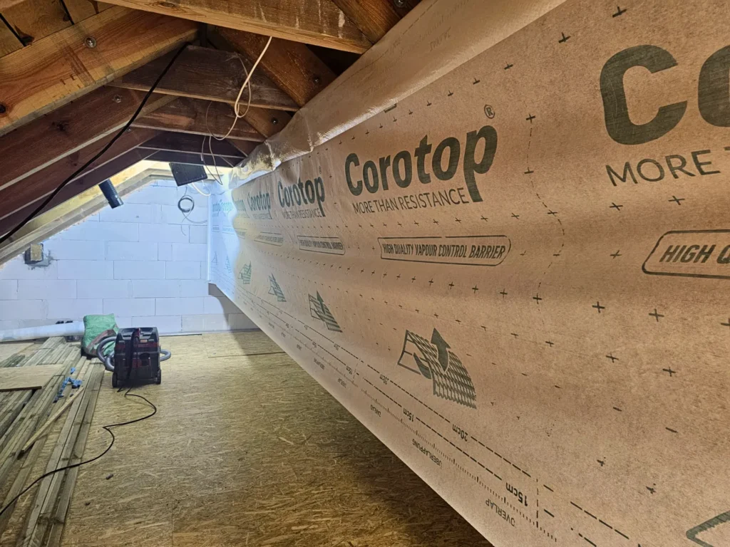 Montaż inteligentnej paroizolacji Corotop Variant na krokwiach poddasza – realizacja Hot Space, Mazury